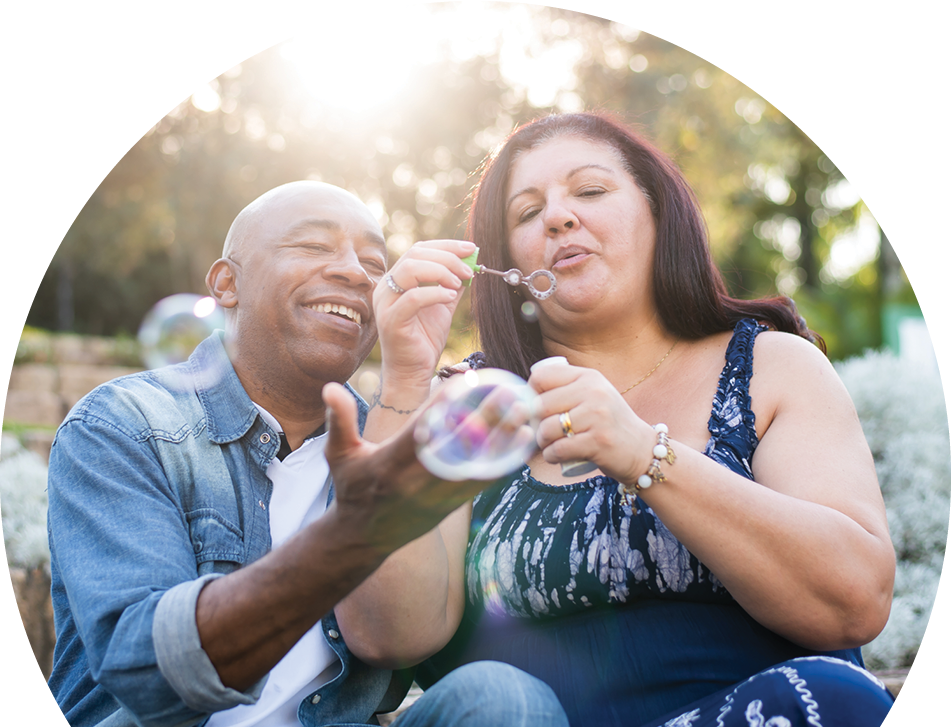 Man and a woman in the park blowing bubbles