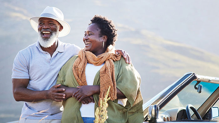 Man and woman standing next to car
